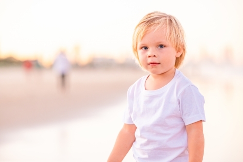 Toddler boy playing on wet sand on Gold Coast beach - Australian Stock Image