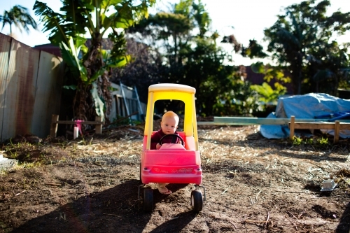 Toddler in a toy car - Australian Stock Image