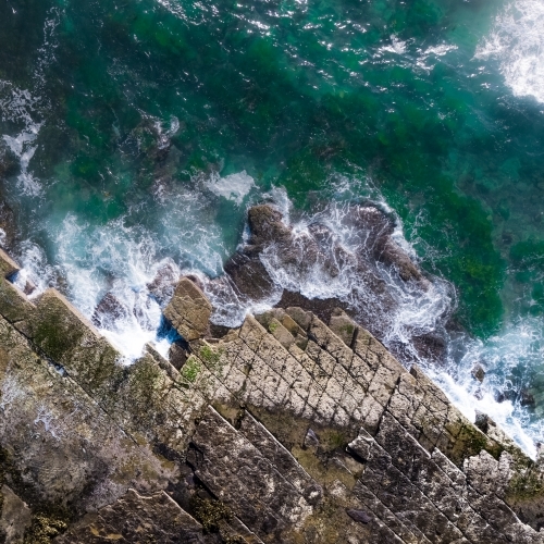 Top down aerial of rock shelf and ocean waves at Turimetta Beach on Sydney's Northern Beaches - Australian Stock Image