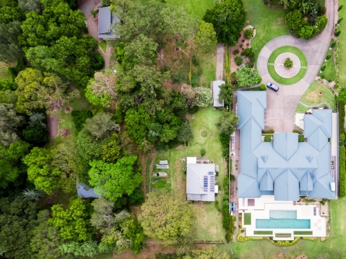 Top down aerial view of luxury homes beside small original house - Australian Stock Image
