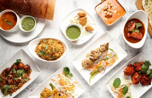 Top down of various appetising Indian dishes on table - Australian Stock Image