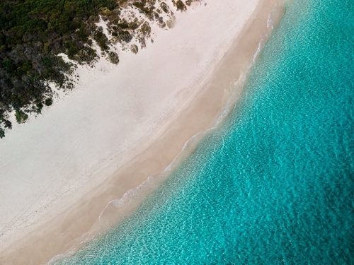 top shot of a white sand beach with grass and bushes on a sunny day - Australian Stock Image