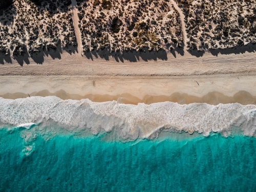 top shot of  sea waves, white sand shores, bushes and trees on a sunny day - Australian Stock Image