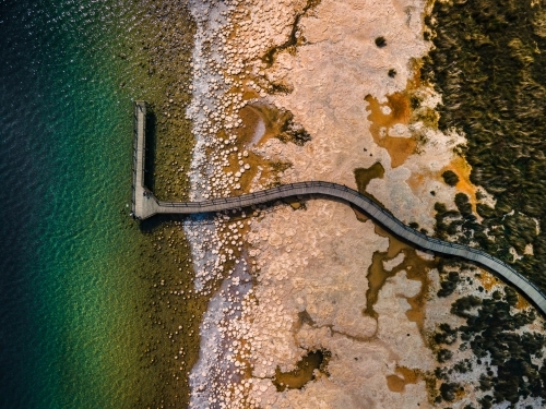 top view shot of a beach walkway with bushes, trees and waves on a sunny day - Australian Stock Image