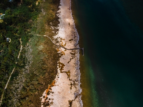 top view shot of a beach walkway with bushes, trees and waves on a sunny day - Australian Stock Image