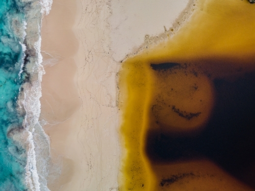 top view shot of a beach with waves and yellow sand - Australian Stock Image