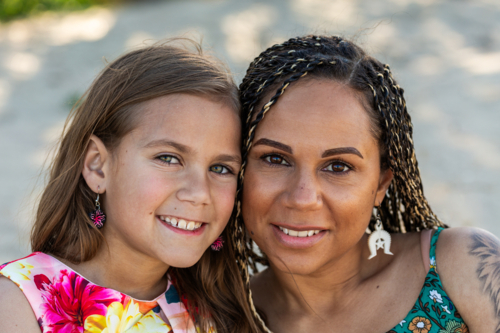 Torres Strait Islander girls face beside mother with hazel and brown eyes - Australian Stock Image