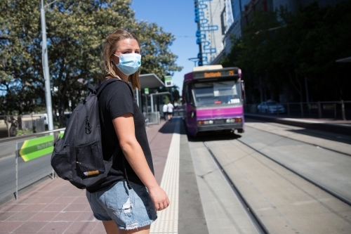 Tourist in Face Mask Catching the Tram - Australian Stock Image