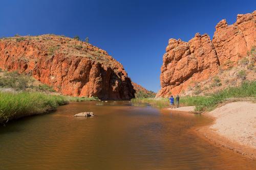 Tourists beside a river coming from a gorge - Australian Stock Image