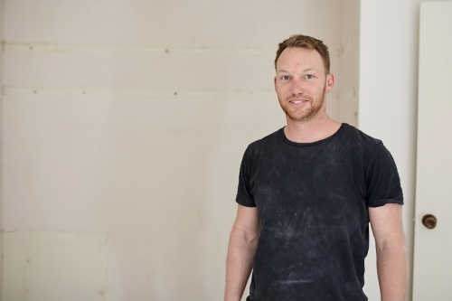 Tradesman standing in a room in a construction zone - Australian Stock Image