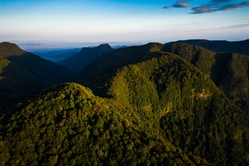 Tree-covered mountain landscape in late afternoon - Australian Stock Image