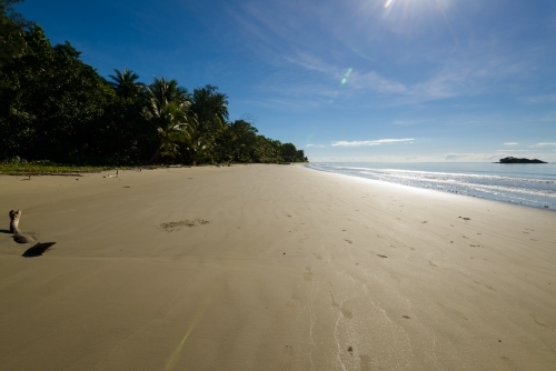 Tropical beach scene with silvery shimmering light and flare - Australian Stock Image