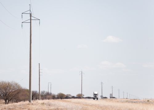 Truck and power poles on remote highway - Australian Stock Image