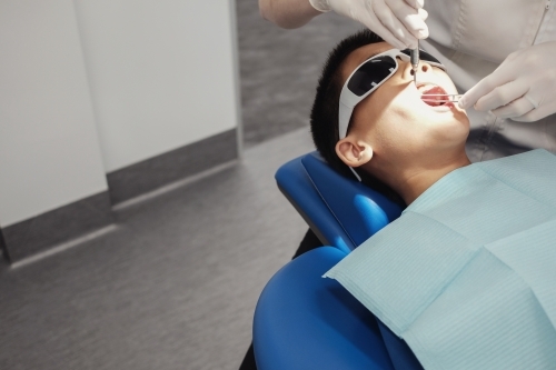 Tween boy having his teeth checked by dentist, oral health - Australian Stock Image