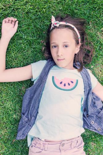 tween girl with watermelon t-shirt, overhead, looking at camera - Australian Stock Image