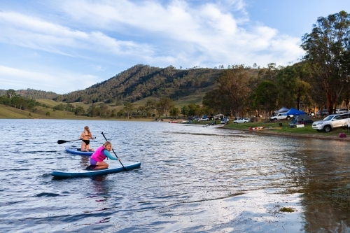 Two Aussie kids out on paddle board on Lake St Clair in summer  - Australian Stock Image