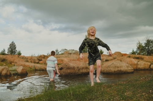 Two boys swimming  fully clothed waterhole in Australian bush - Australian Stock Image