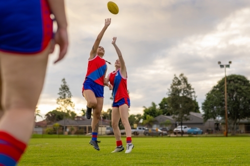 two female football players jumping for the ball at training - Australian Stock Image