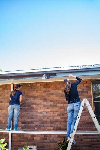 Two female painters Painting home exterior - Australian Stock Image