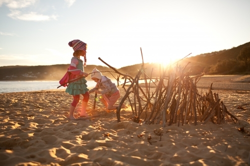 Two girls building a sculpture at the beach - Australian Stock Image