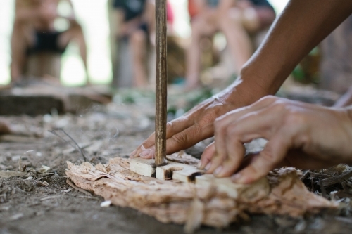 Two hands engaged in flint knapping to create fire. - Australian Stock Image