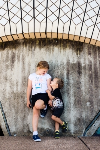 two kids posing for photos at the base of sydney opera house - Australian Stock Image