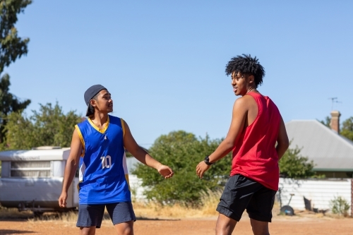 two mates facing up to each other in vacant lot - Australian Stock Image