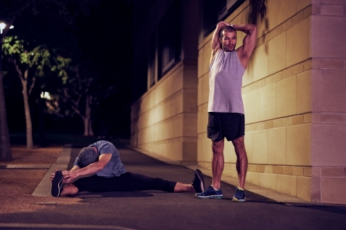 Two men fitness training in urban city at night - Australian Stock Image