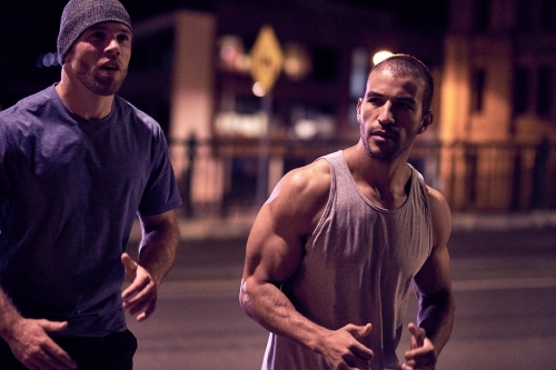 Two men fitness training in urban city at night - Australian Stock Image