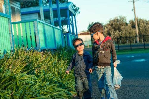 Two mixed race brothers holding hands and walking through a coastal NSW holiday park - Australian Stock Image