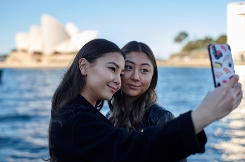 Two sisters spending time together harbourside taking selfie - Australian Stock Image