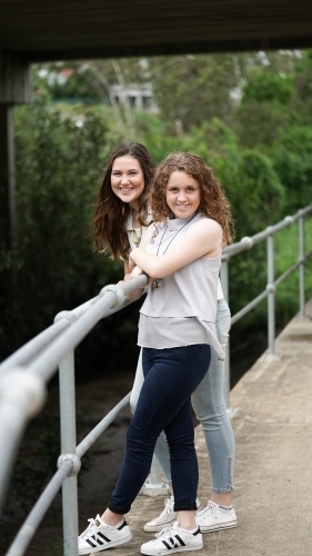 Two teenage girls standing by railing - Australian Stock Image