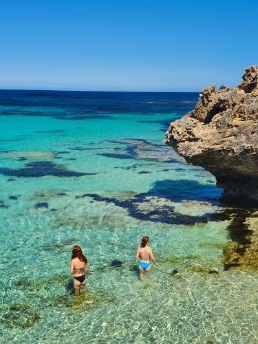 Two teenage girls wading in the ocean - Australian Stock Image