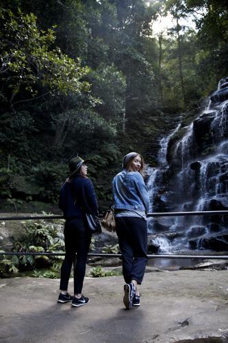 Two women on bush walk looking at waterfall - Australian Stock Image