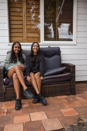Two young Aboriginal women sitting together - Australian Stock Image