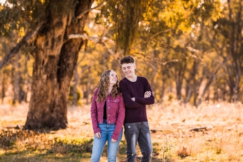 Two young adults looking at each other smiling - Australian Stock Image