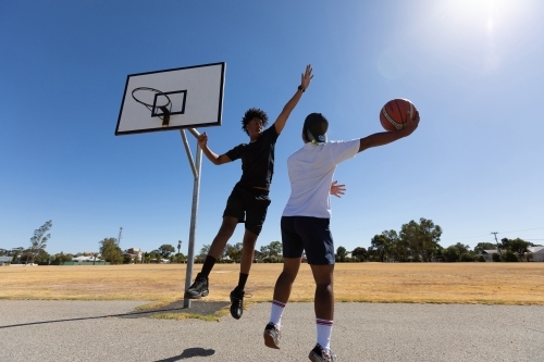 two young guys playing one-on-one basketball - Australian Stock Image