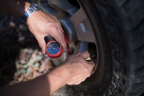 Tyre pressure adjustment in preparation for off-road 4WD - Australian Stock Image