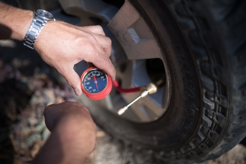 Tyre pressure adjustment in preparation for off-road 4WD - Australian Stock Image