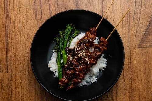 Venison / Beef Bbq skewers on rice with broccolini - Australian Stock Image