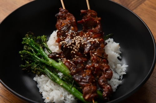 Venison Skewers with broccolini on rice - Australian Stock Image