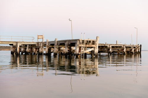Venus Bay jetty reflecting on calm morning water - Australian Stock Image