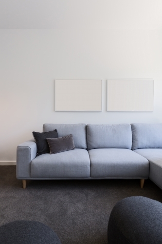 Vertical image of pastel blue sofa with blank artwork above - Australian Stock Image