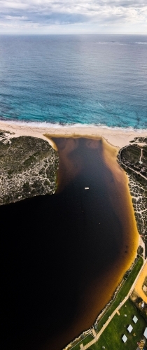 vertical shot of an island with floating platform, bushes, yellow and white sand on a sunny day - Australian Stock Image