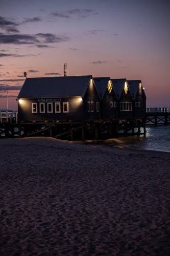 vertical shot of beach buildings with walkway under cloudy sunset skies - Australian Stock Image