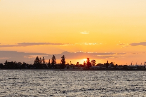 Vibrant orange sunset over Stockton NSW - Australian Stock Image