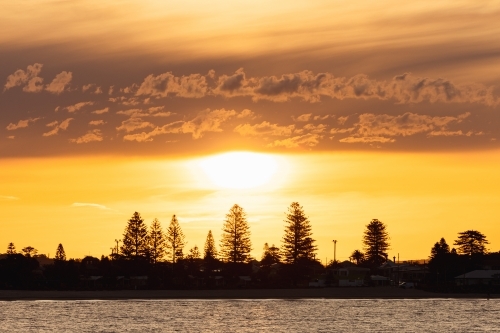 Vibrant orange sunset over Stockton NSW with view across the water - Australian Stock Image