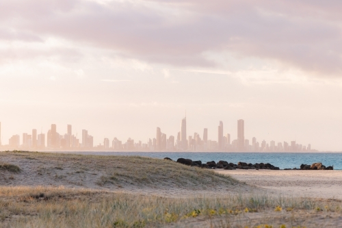 View of Gold Coast city skyline from Currumbin Beach at sunset - Australian Stock Image