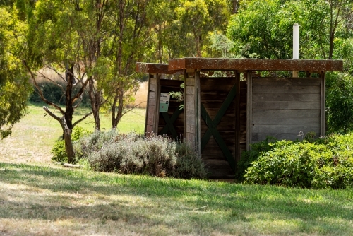 View of old wooden toilet buildings in a park. - Australian Stock Image