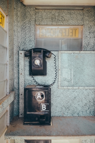 Vintage black telephone inside an old phone box